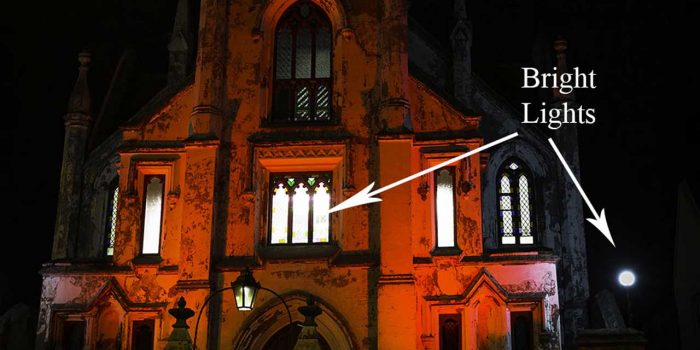 this image shows an old church photographed at night with bright red lights and is featured in in understanding the histogram blog